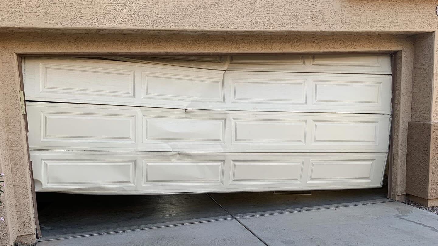 Dented garage door panels after an impact